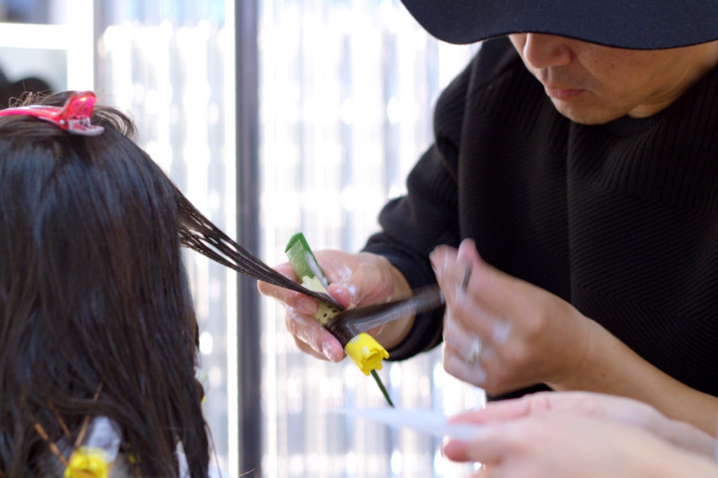 Salón paquete ANTI - Imagen 4 - estilistas que aplican la solución permanente en el cabello